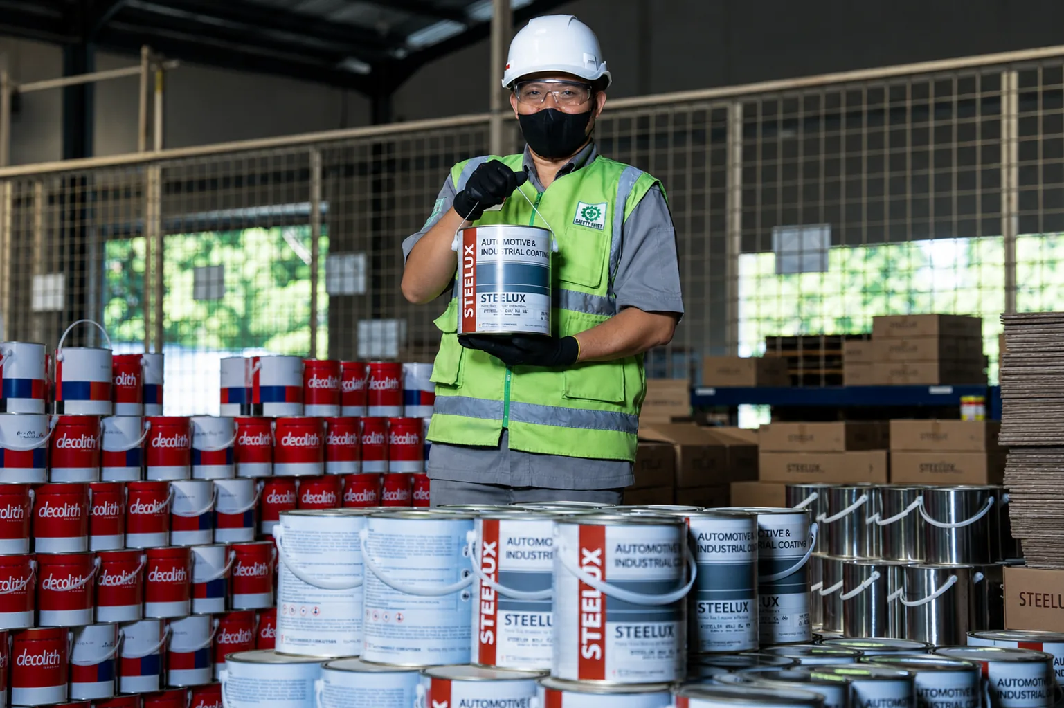 VK warehouse operator presenting a Steelux automotive and industrial coating can